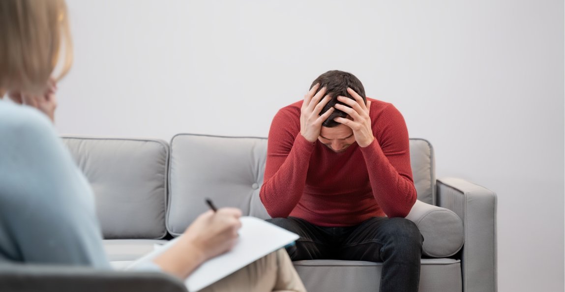 Мужчина держится за голову на прием у врача